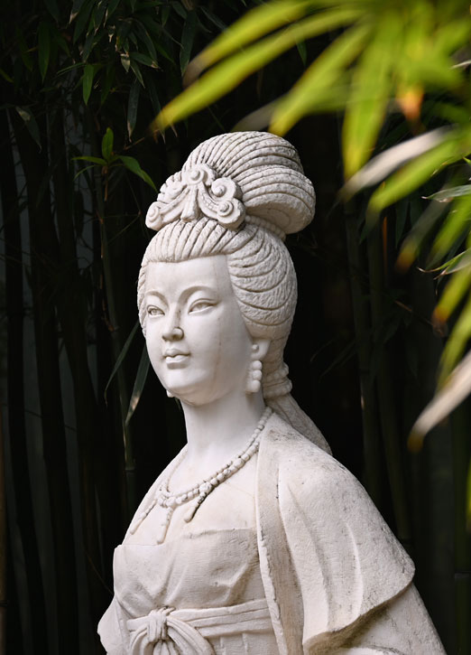 woman-statue classic statue of a woman in a bamboo oasis garden